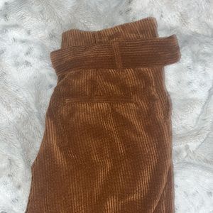 Brown corduroy pants. Comes with a small belt, cuffed at the bottom.